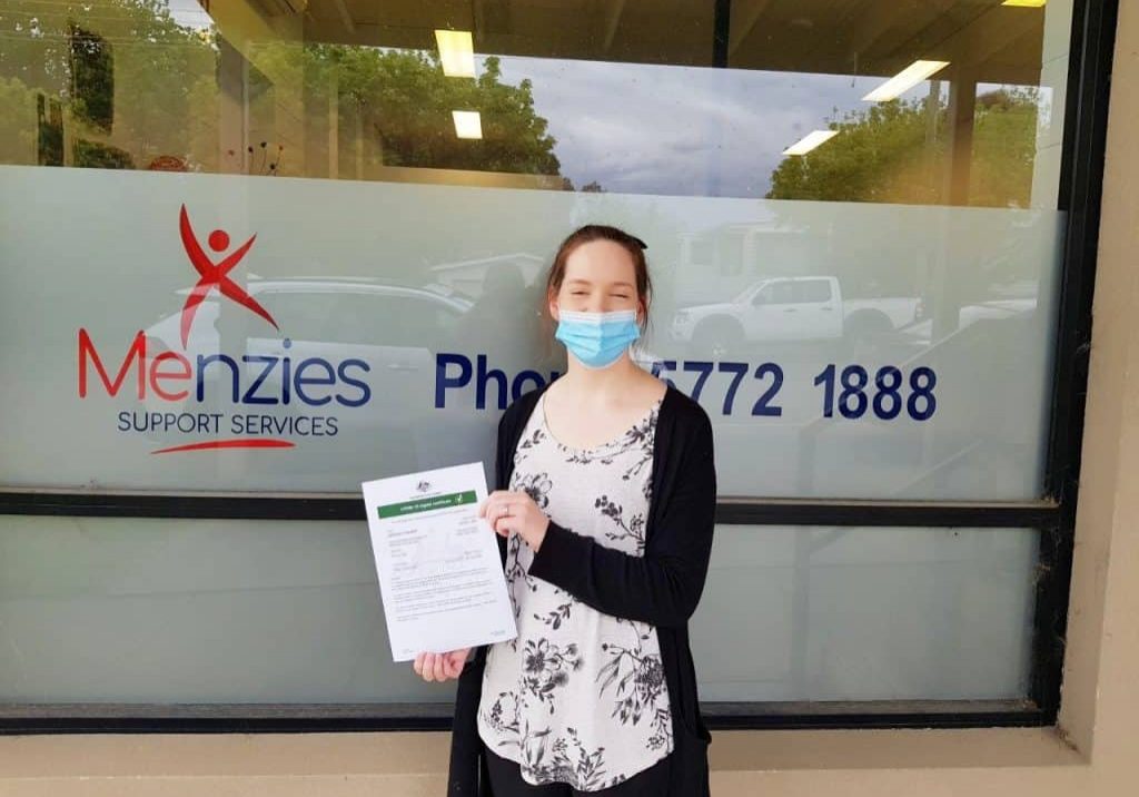Jess, Disability Services Assistant, has received both doses of vaccine. Jess is pictured with a printout of her digital certificate.