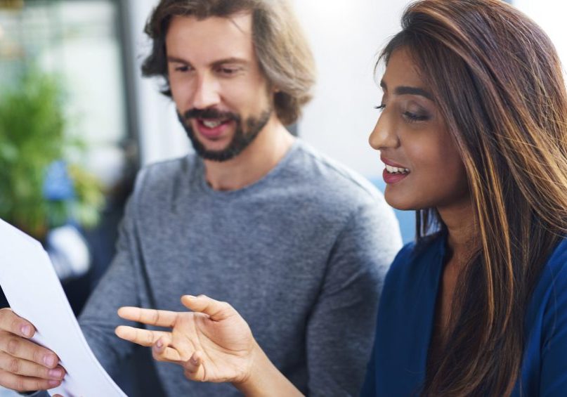 Young adults coworkers analyzing document